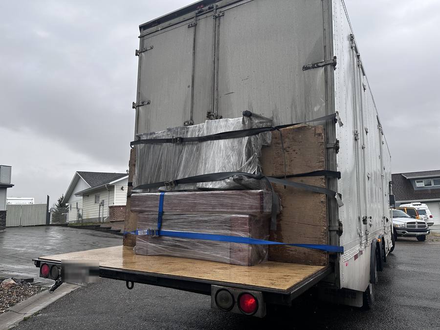 Back of the Western Provincial Movers truck in Dawson Creek, BC, with shrink-wrapped pieces stacked on the liftgate and strapped down, October 2025