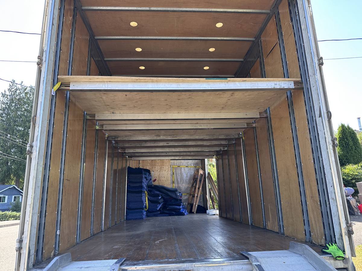 Inside the empty Western Provincial Movers truck in Nanaimo's Departure Bay area, decking beams up, blankets stacked at the front and the ramp down