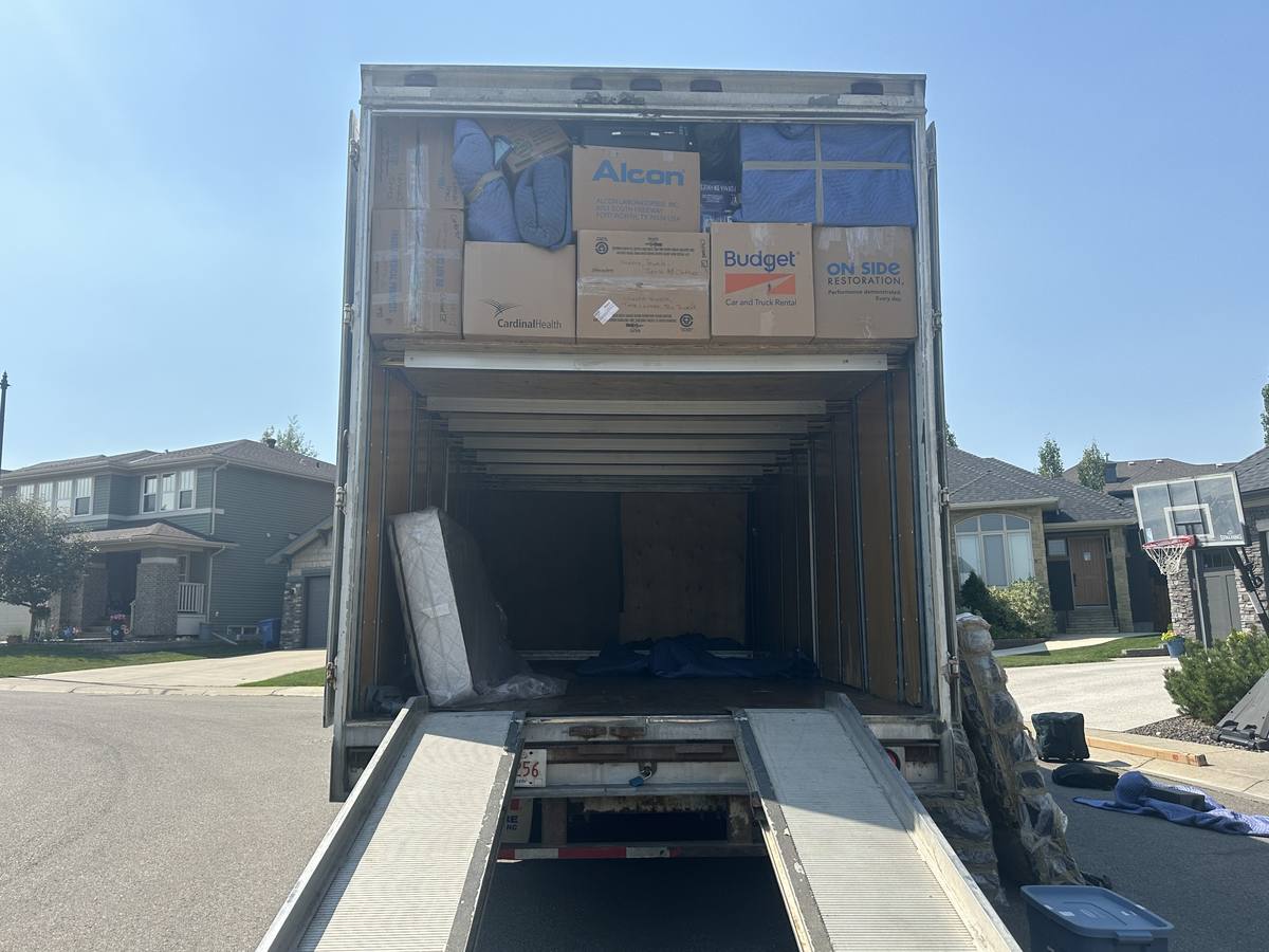 Moving truck with its ramps down and a full upper deck on a Western Provincial Movers job in Evergreen, Calgary, August 2024